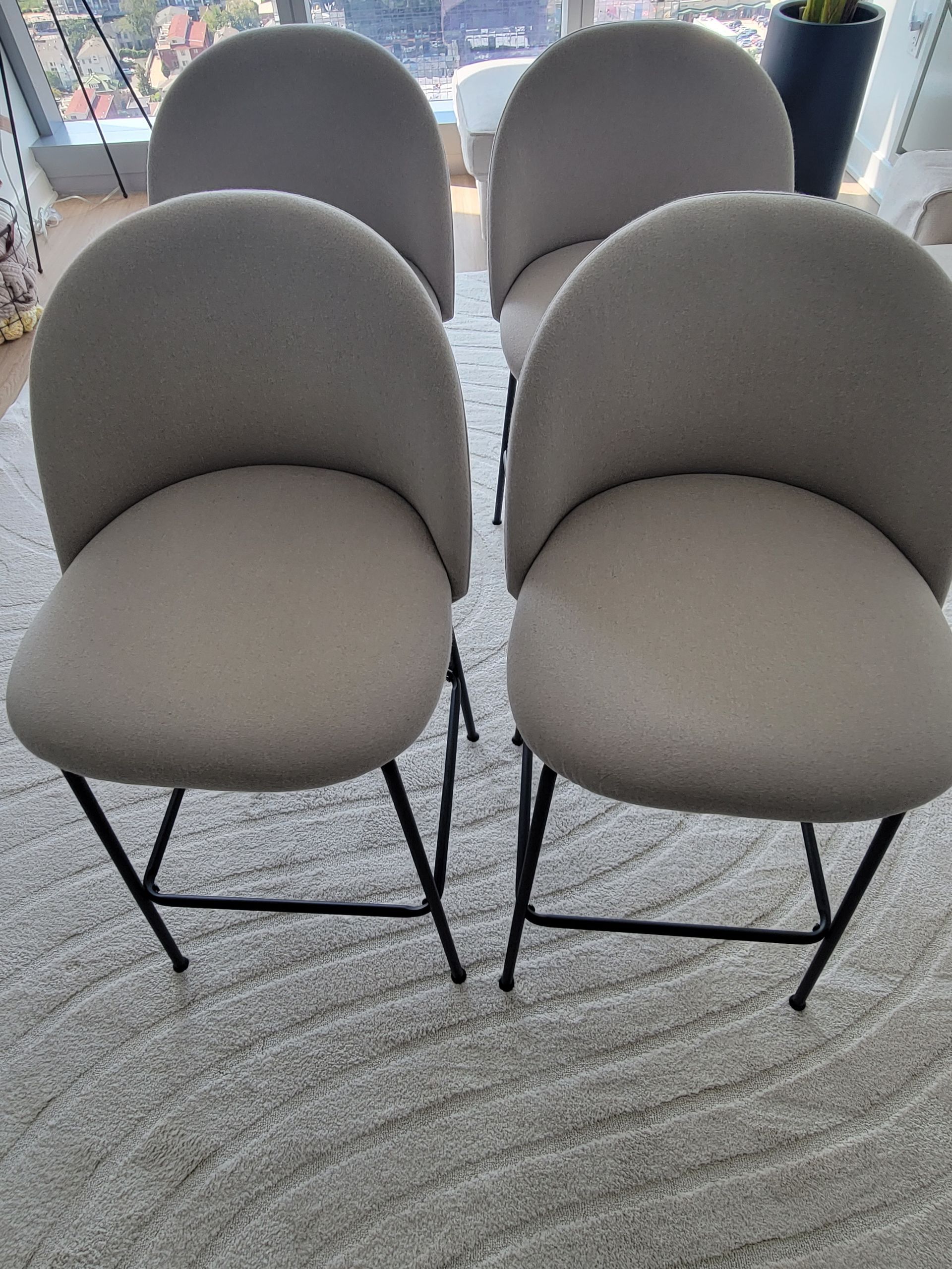 Four chairs are sitting on a rug in a living room.