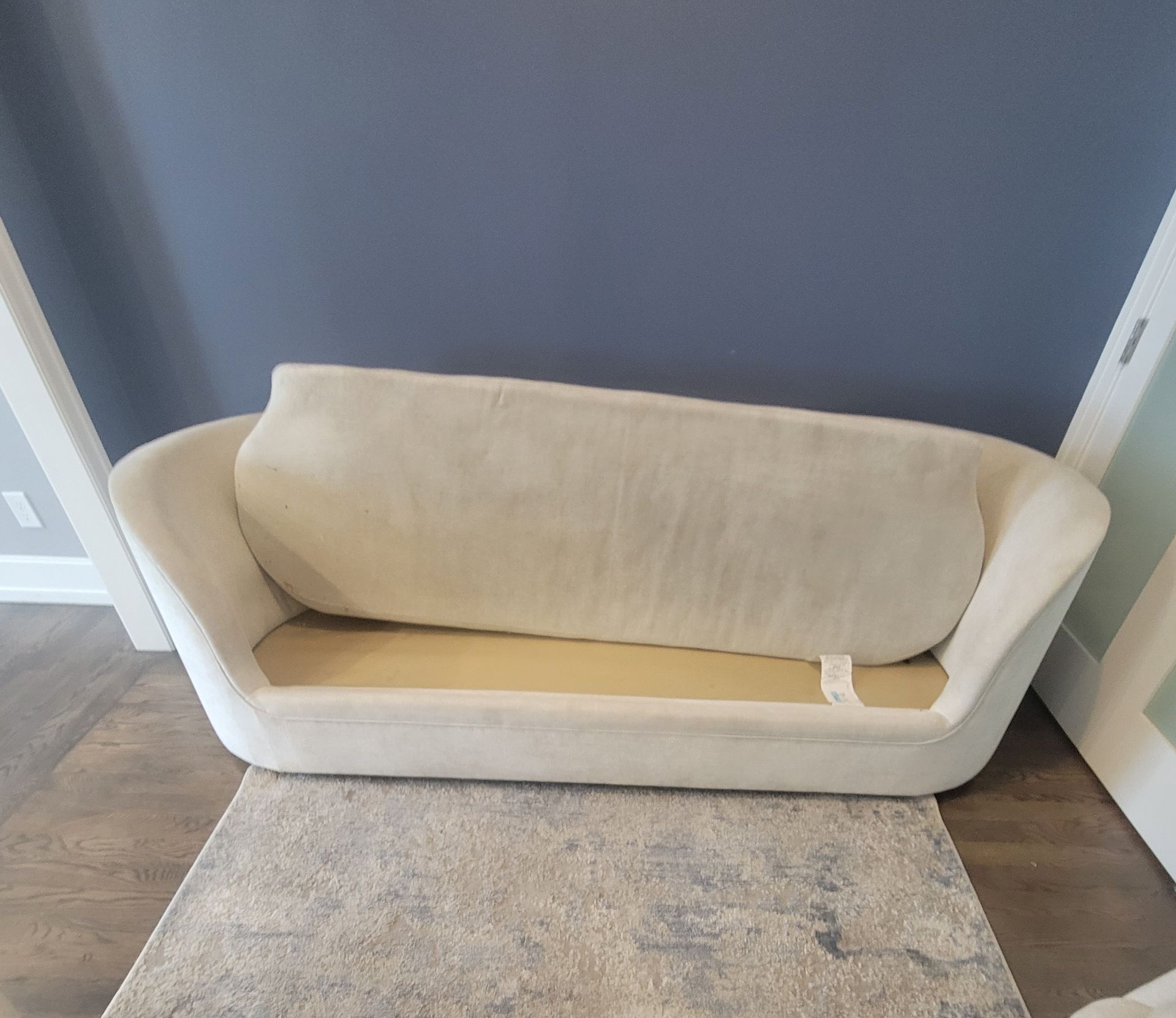 A white couch is sitting on a rug in a living room.