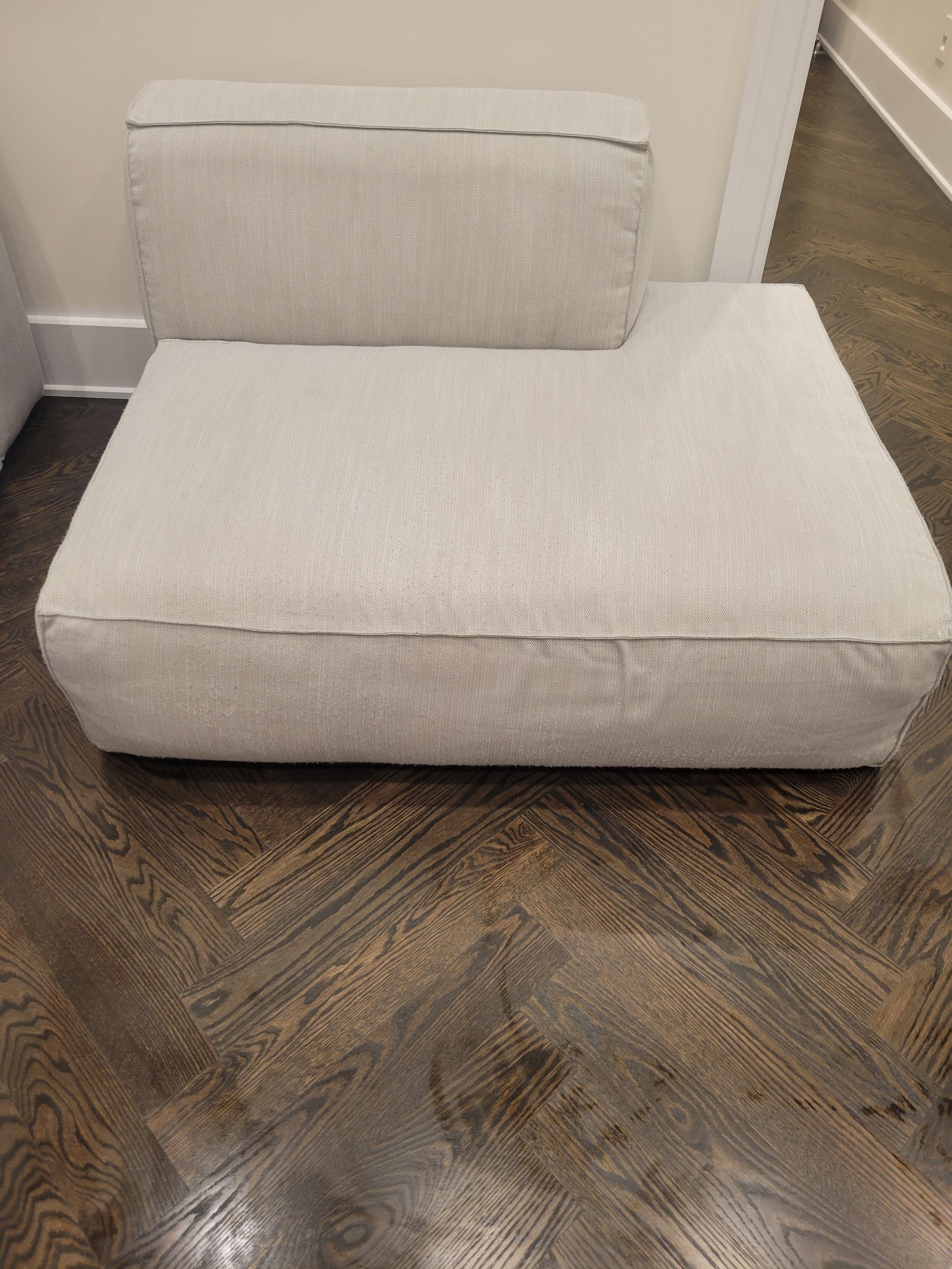 A white chair is sitting on a wooden floor.