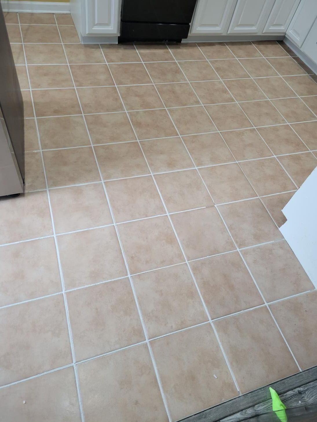 A kitchen with a tile floor and white cabinets.