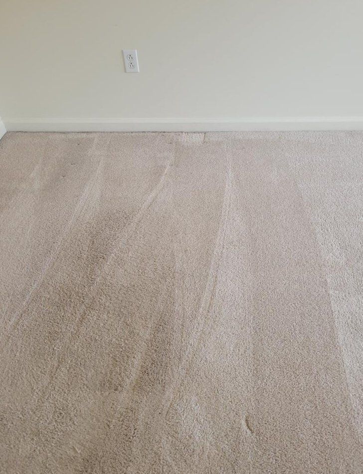 A room with a carpeted floor and white walls.