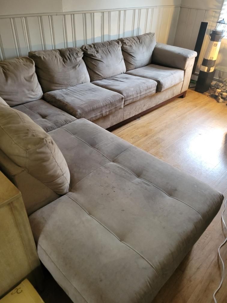 A large sectional couch is sitting in a living room.