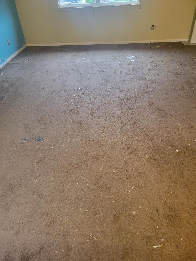 A room with a dirty carpet and a window.