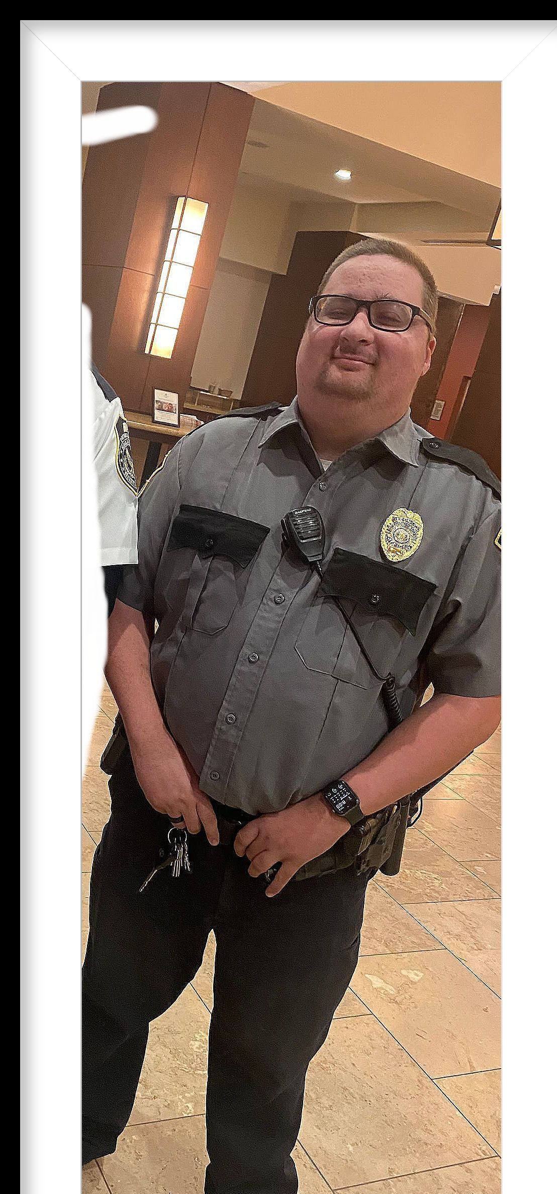 A man in a police uniform is standing in a room.