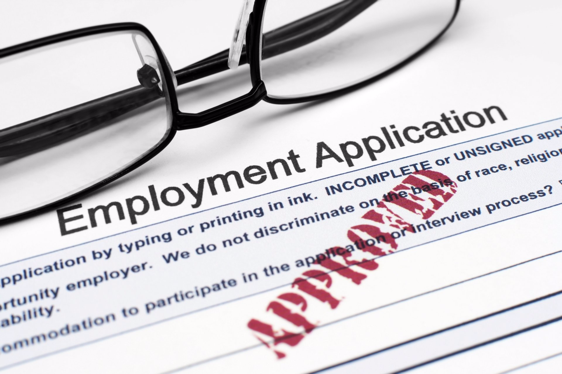 A pair of glasses sits on top of an employment application