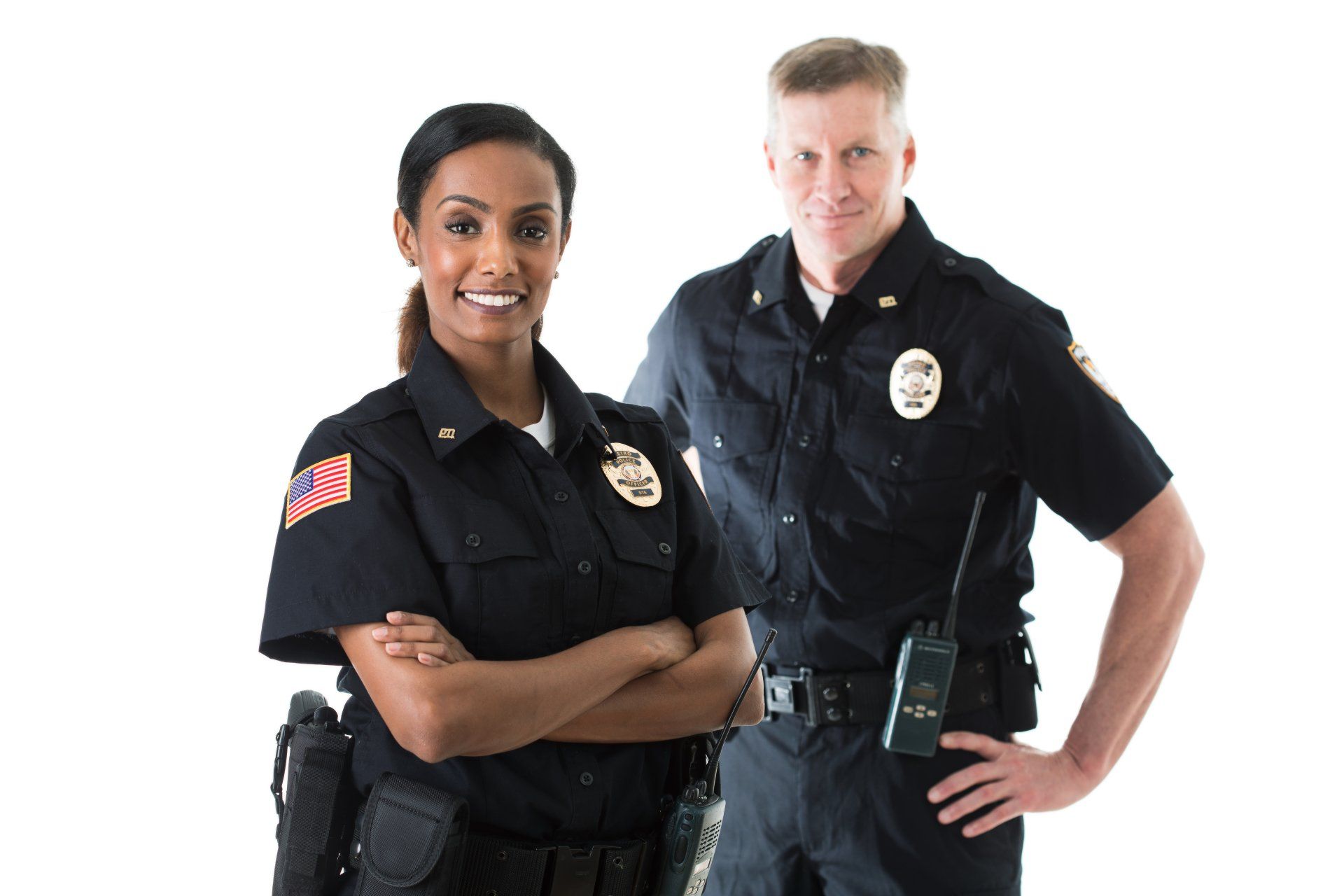 Two police officers in uniform, smiling, posing against a white background. One has arms crossed.