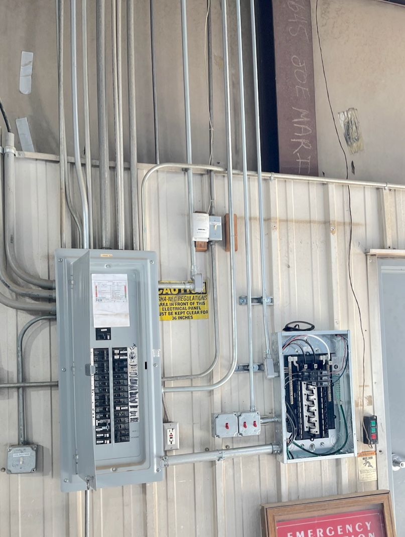 An electrical box on a wall next to a sign that says emergency