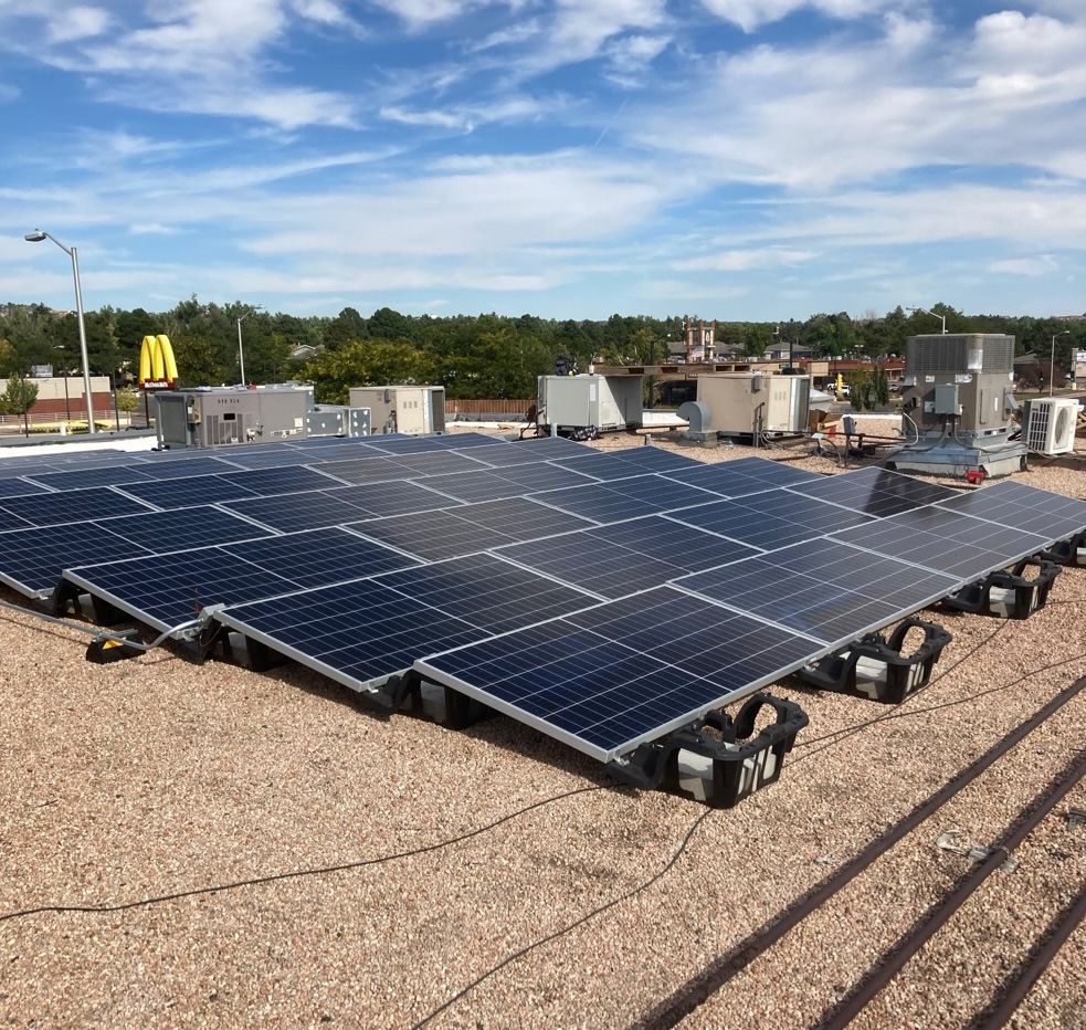 A large amount of solar panels are on the roof of a building