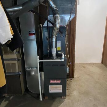 A Goodman furnace and ductwork in a basement. Gray and black.