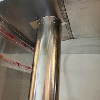 Silver metal pipe extending through a ceiling.