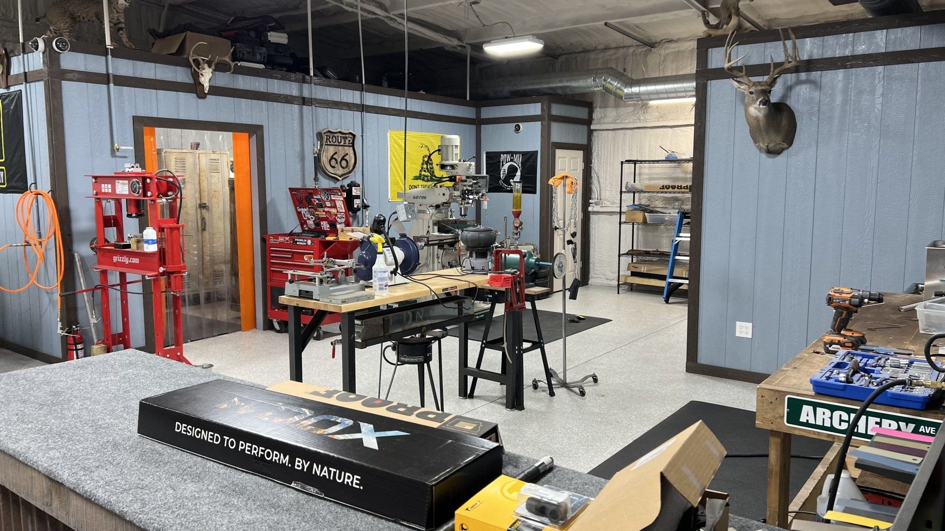 A workshop with a lot of tools and a deer head on the wall.