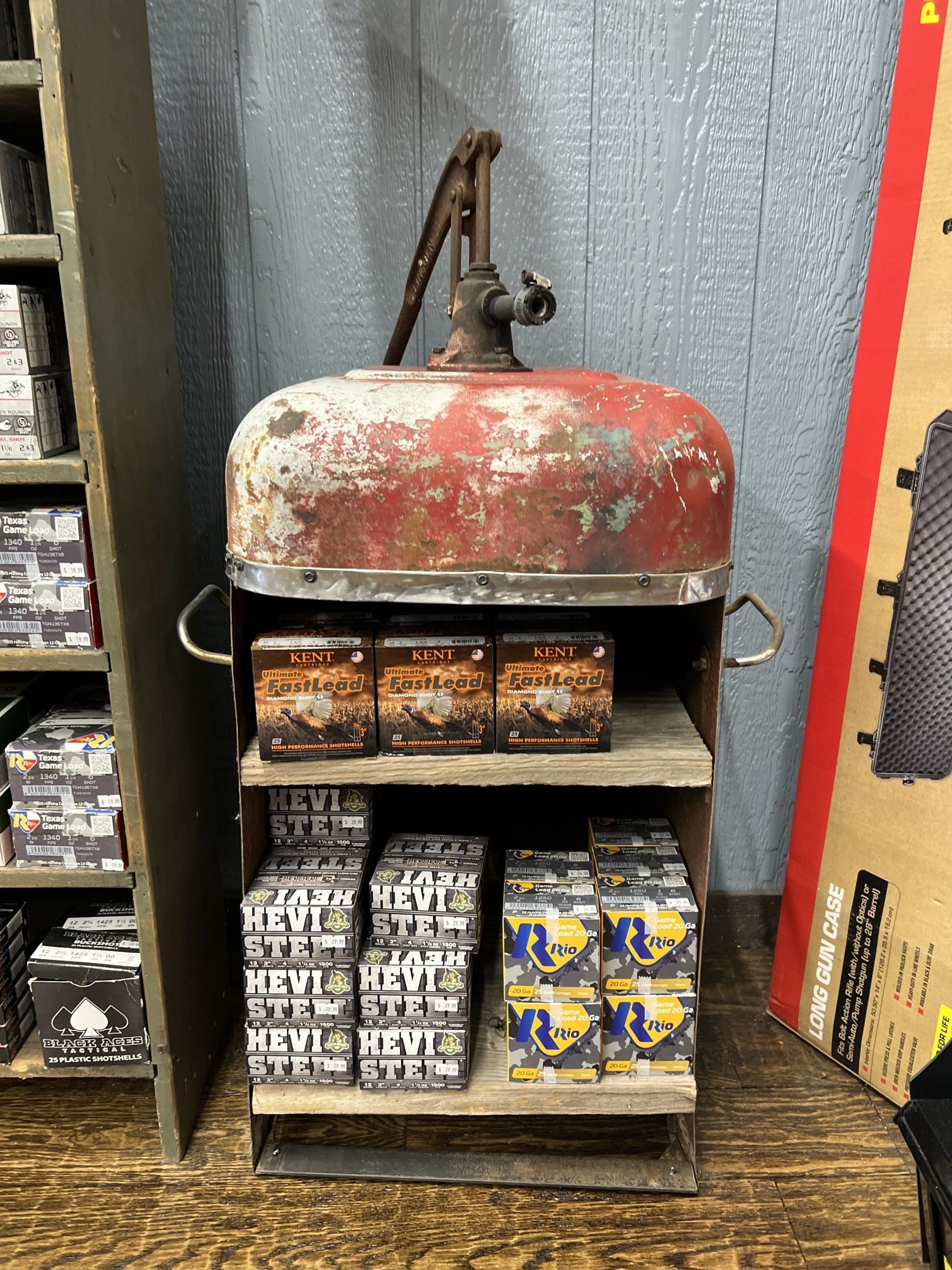 A fire extinguisher is sitting on top of a wooden shelf filled with fireworks.