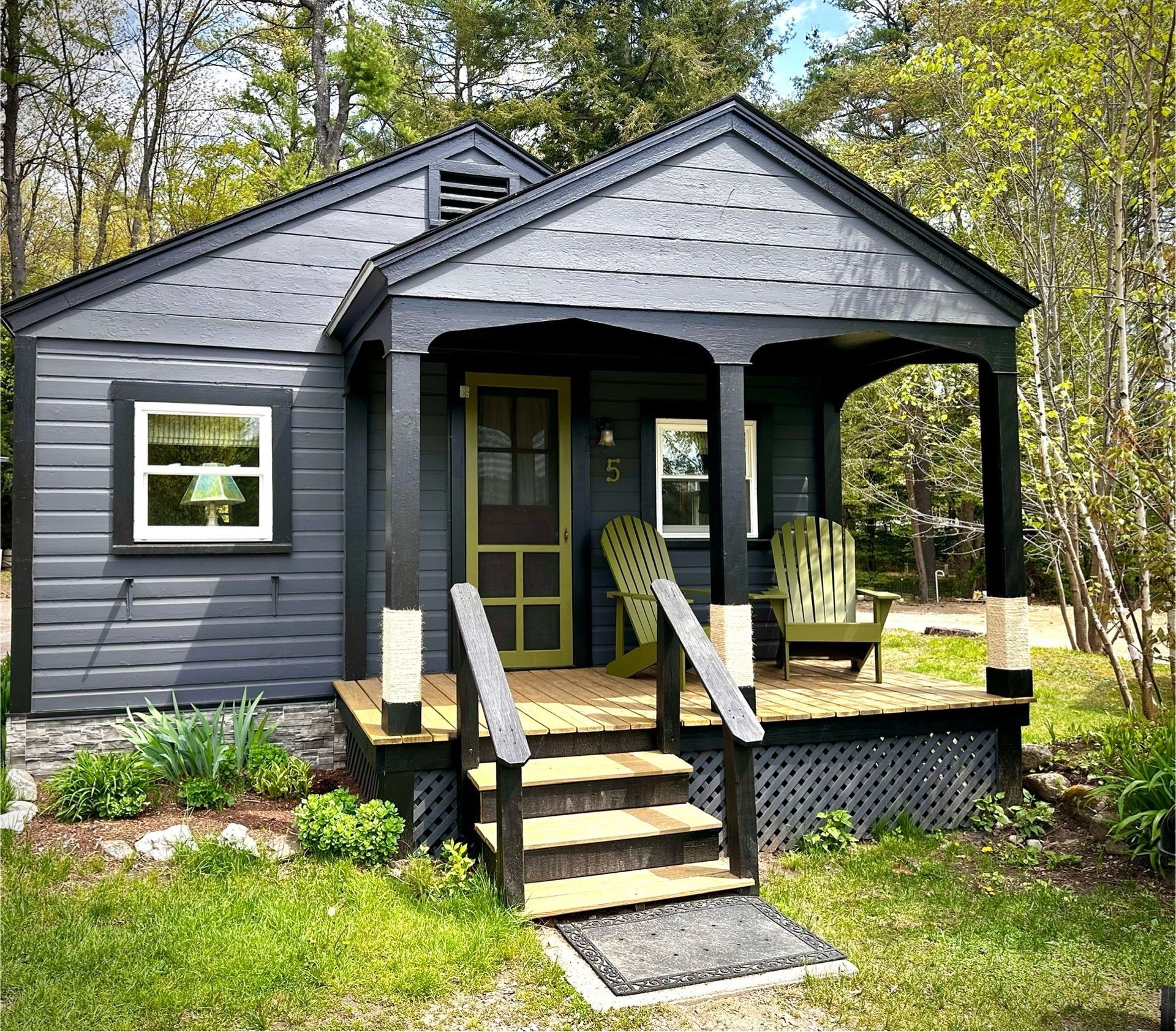A small house with a porch and chairs on it