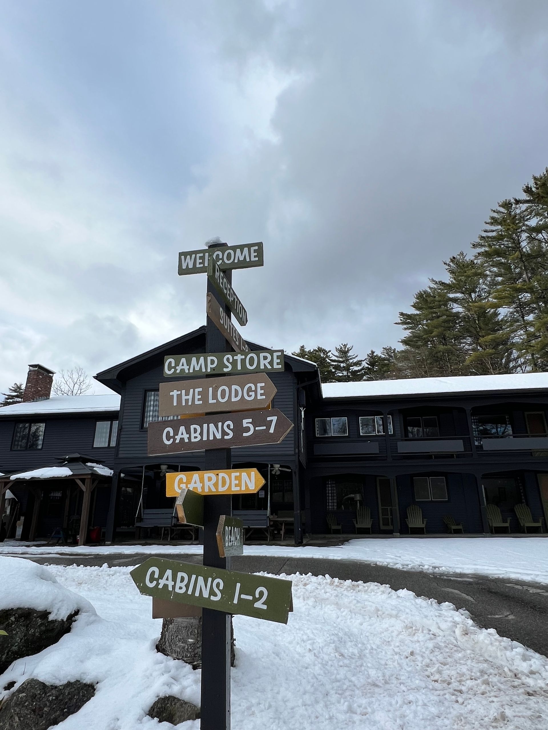 A sign in front of a building that says welcome camp store the lodge cabins 5 7 garden cabins 1-2