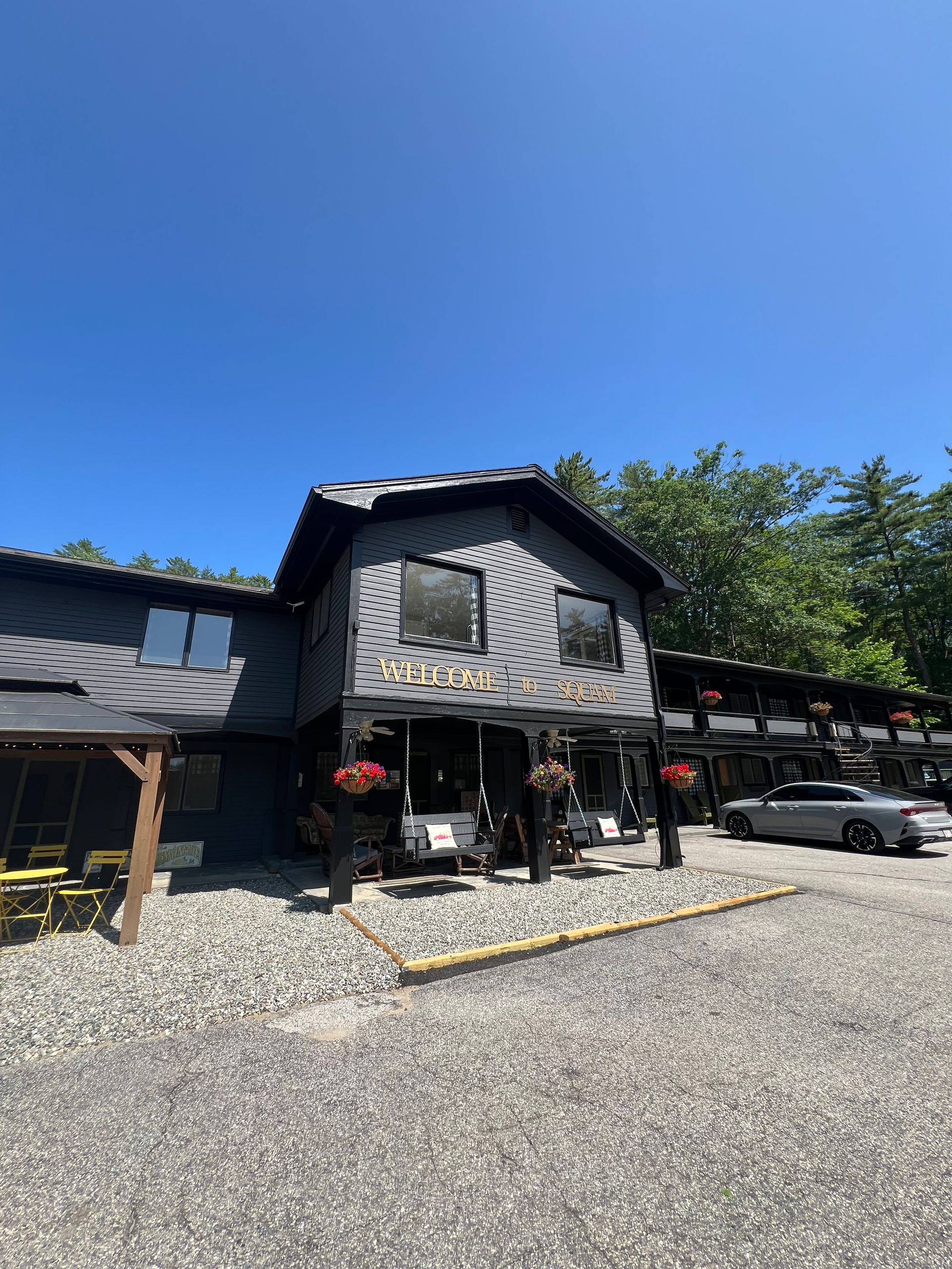 A large black micro hotel with suites and a front office and common area. 