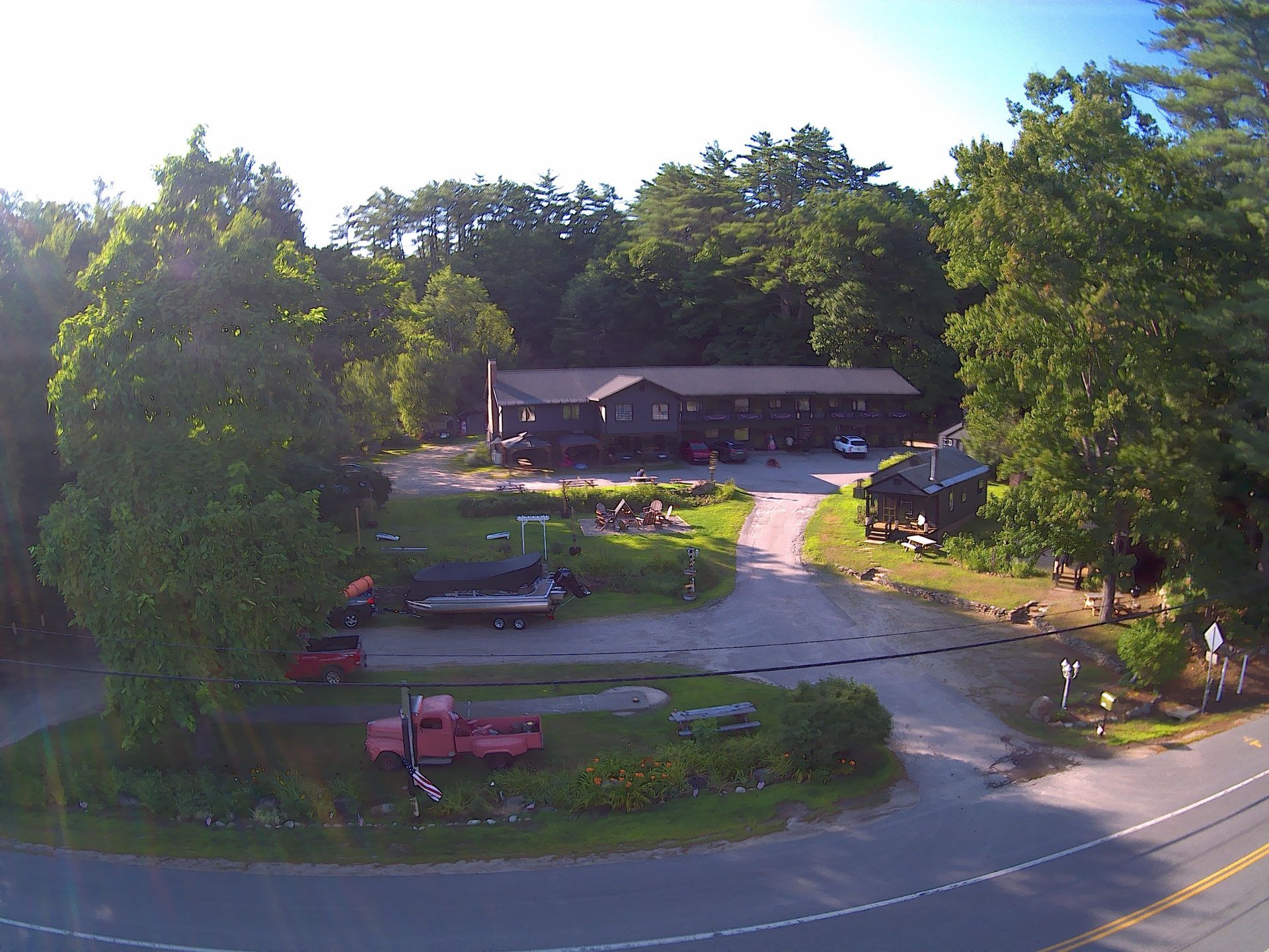 An aerial view of a house surrounded by trees and a road