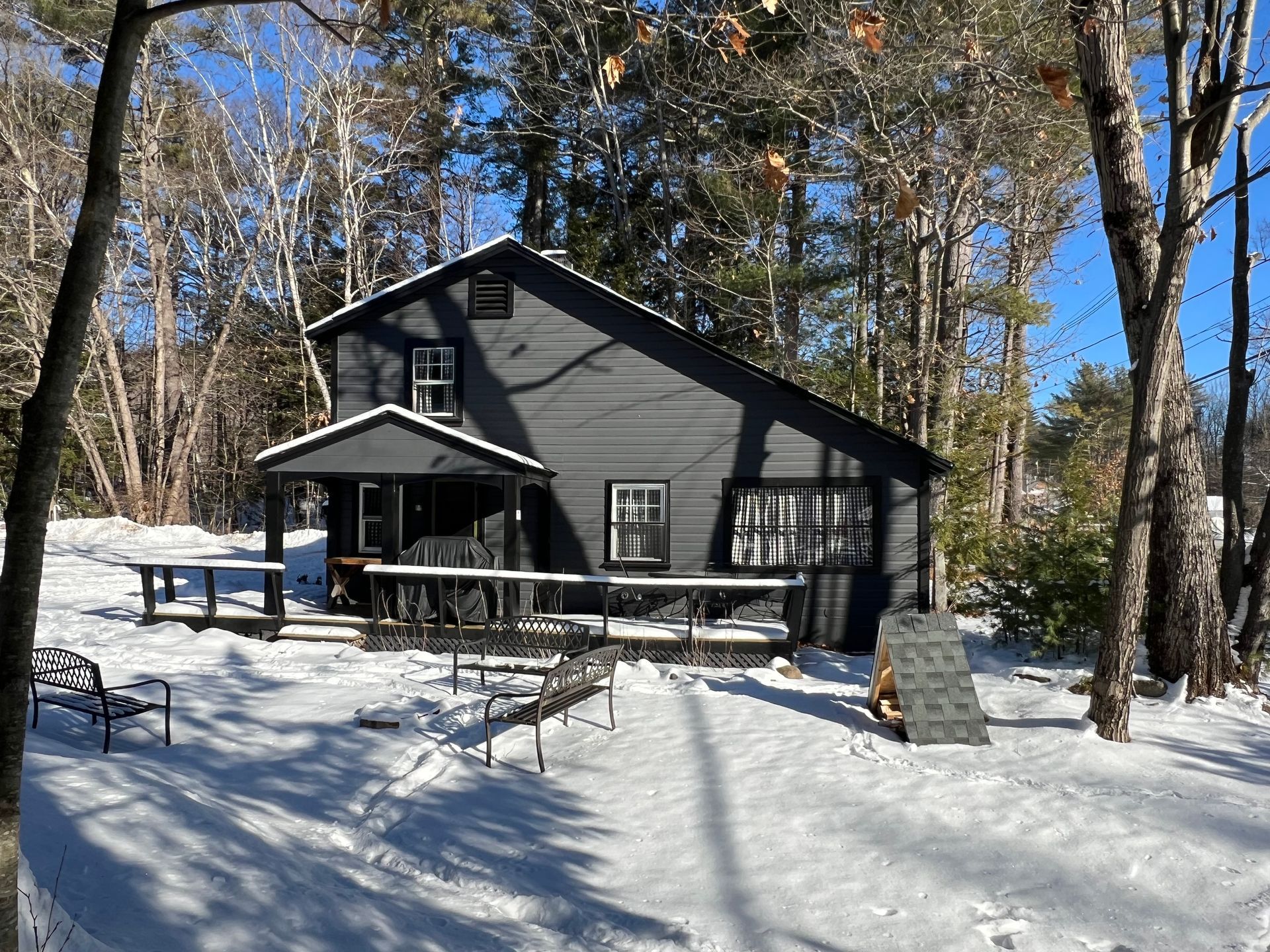 A black house in the middle of a snowy forest