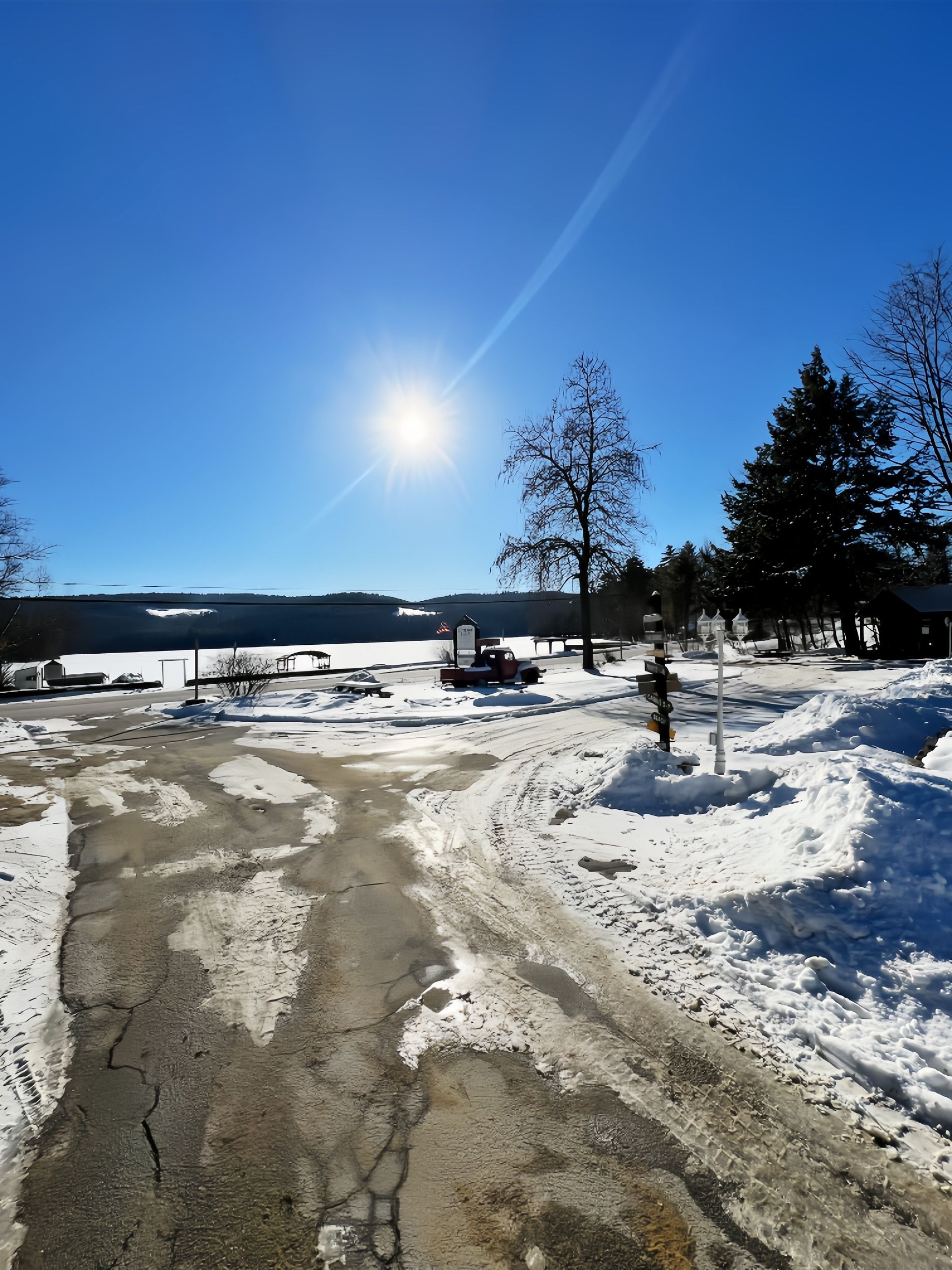 A snowy road leading to a body of water
