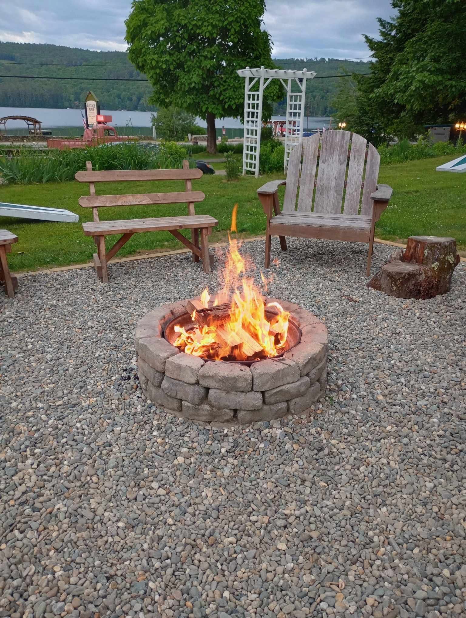 A fire pit with a bench and chairs around it