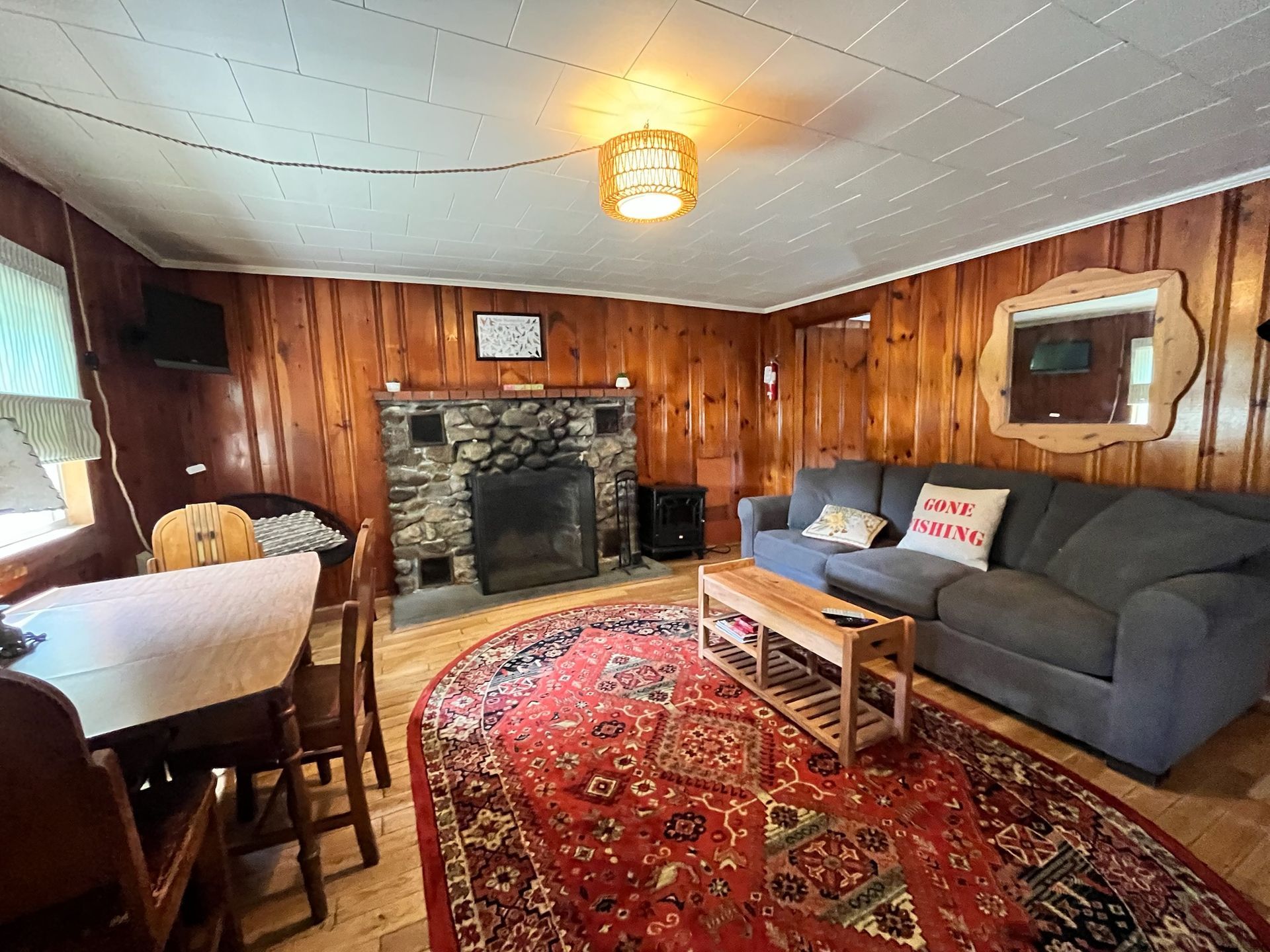 A living room with a couch , table , chairs and fireplace.