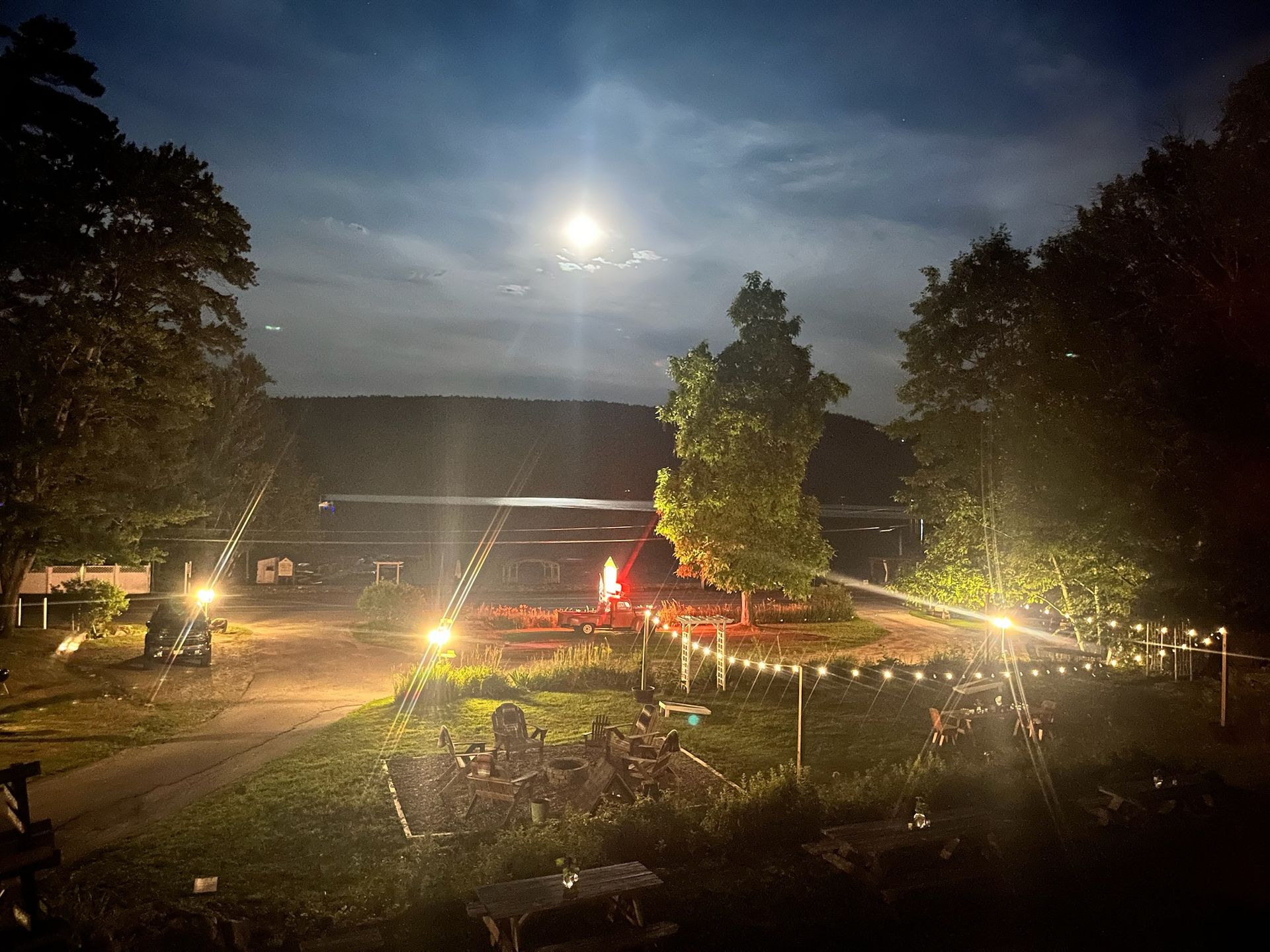 A cemetery is lit up at night with a full moon in the sky.
