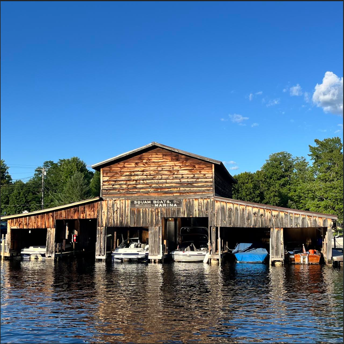 A wooden boat shed with boats inside of it in Holderness NH 