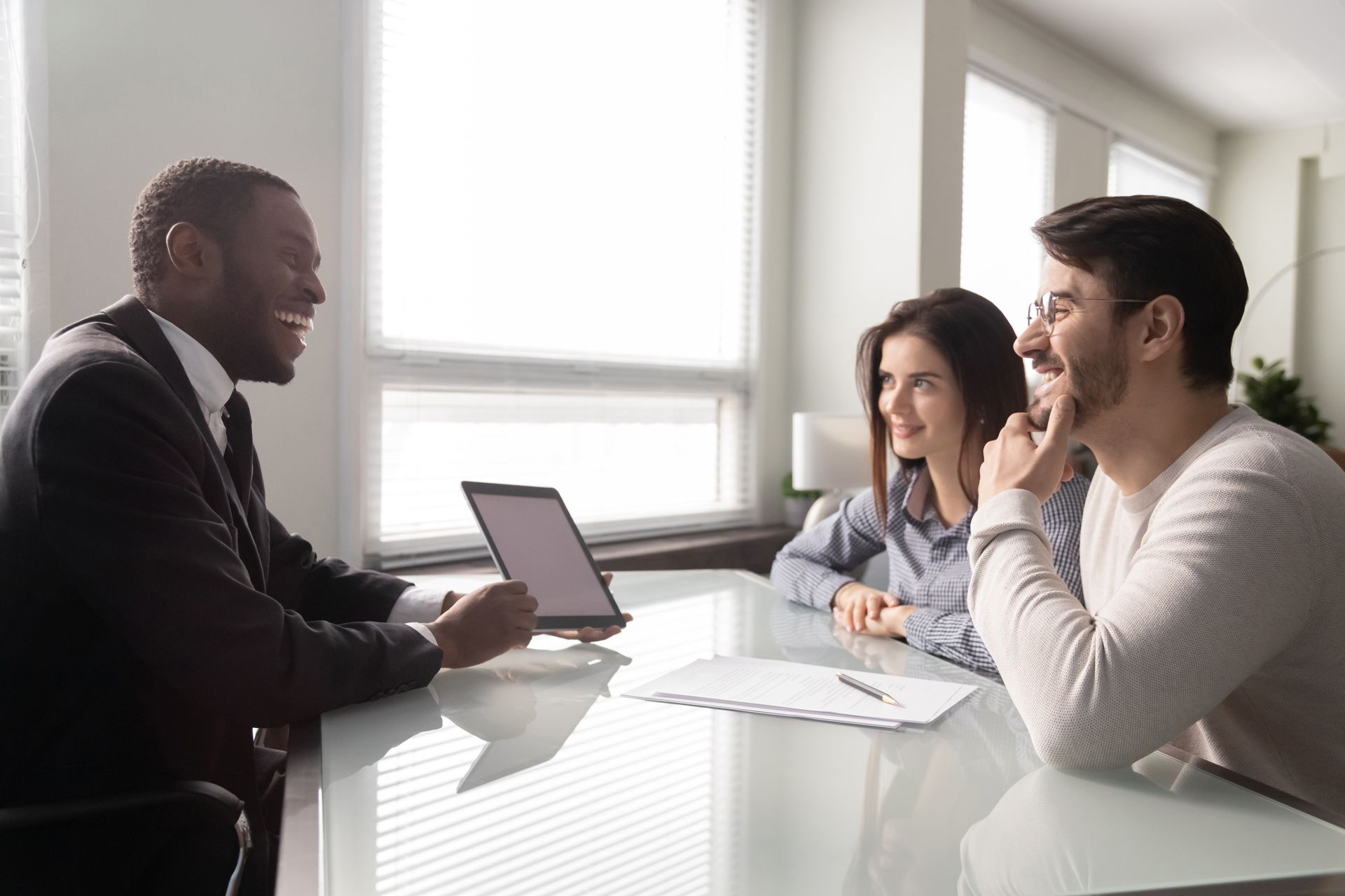A Man is Sitting at a Table Talking to a Couple