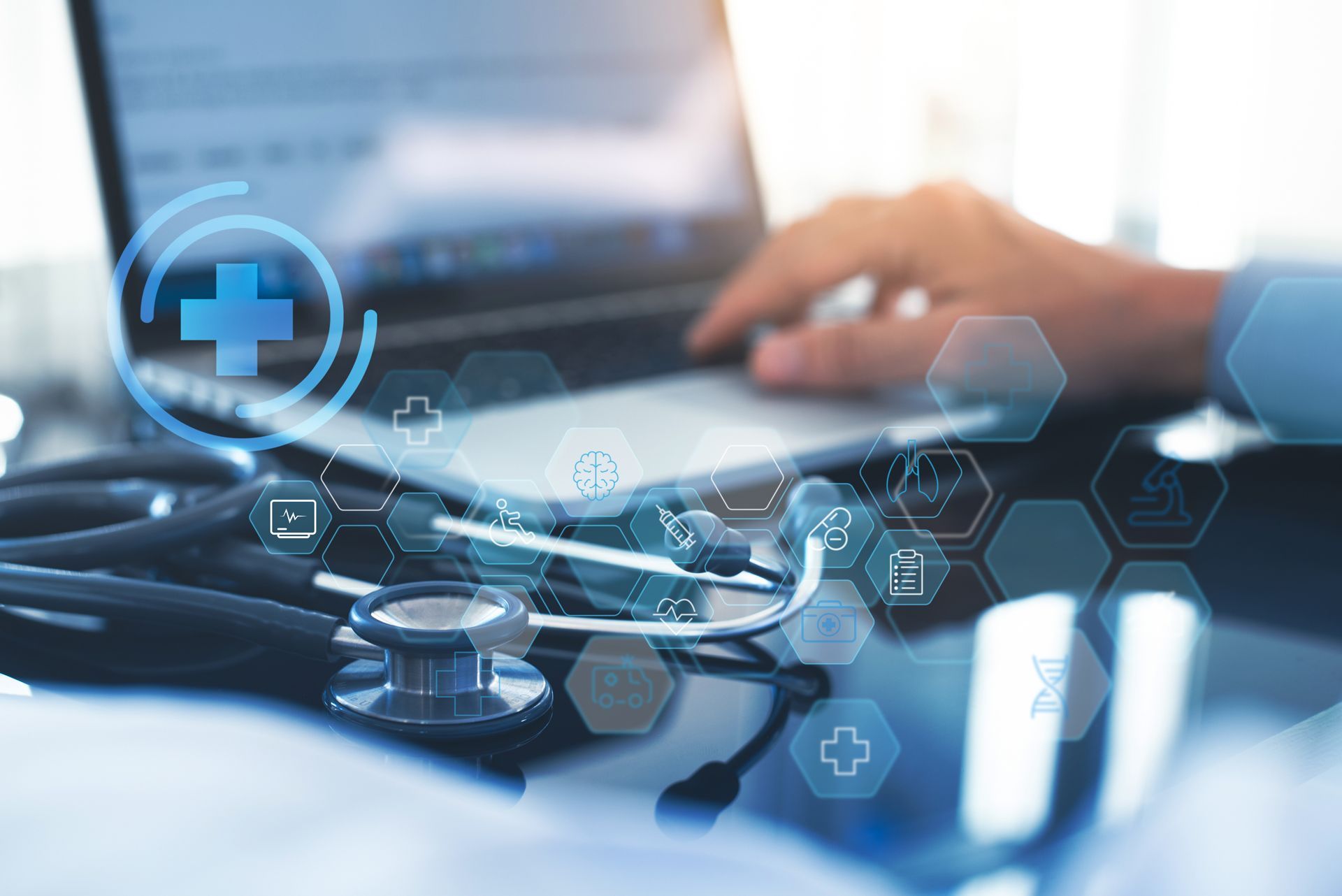 A Doctor is Using a Laptop Computer With a Stethoscope on the Desk