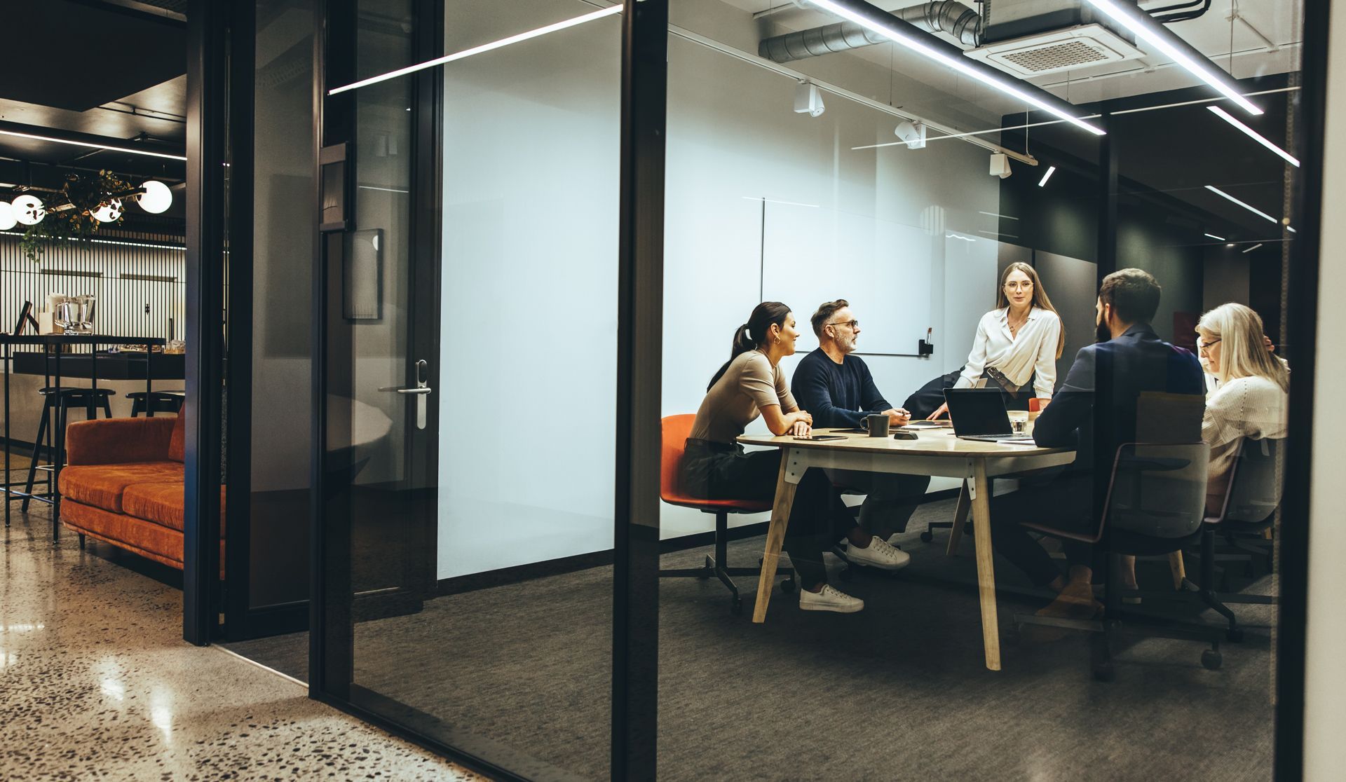 A Group of People Are Sitting Around a Table in a Conference Room