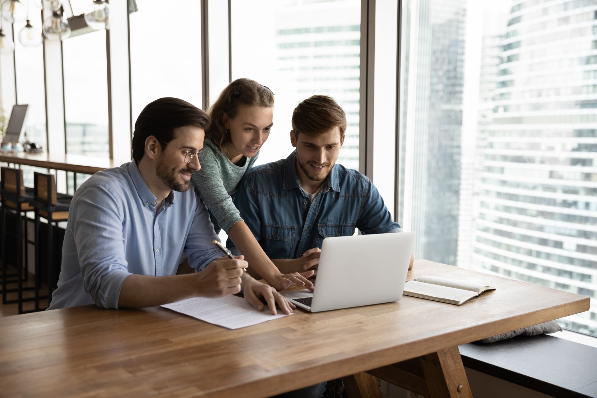 A Group of People Are Sitting at a Table Looking at a Laptop Computer