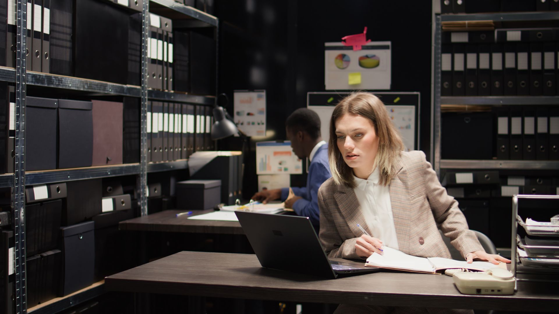 A Woman is Sitting at a Desk Using a Laptop Computer
