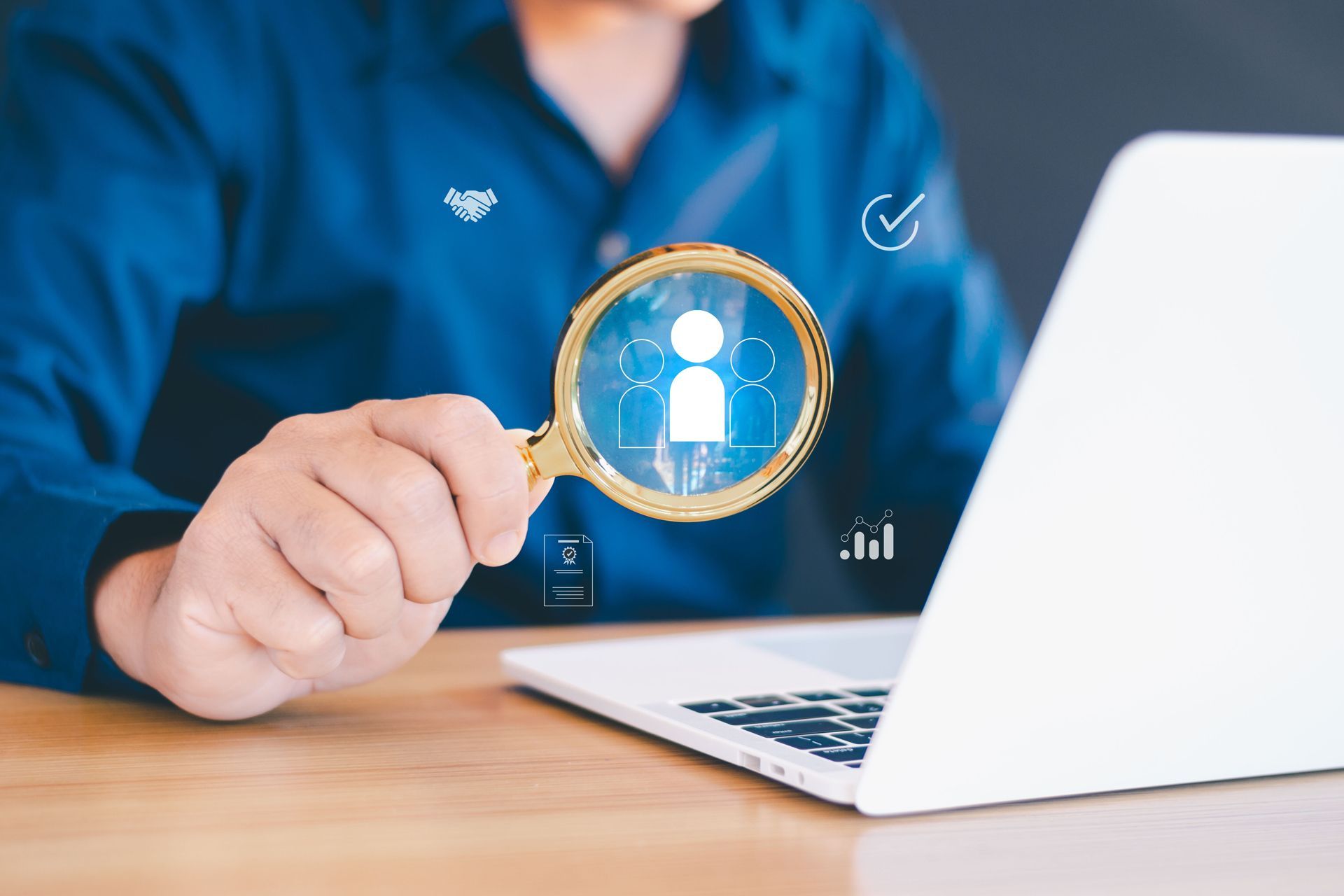 A Man is Holding a Magnifying Glass in Front of a Laptop Computer