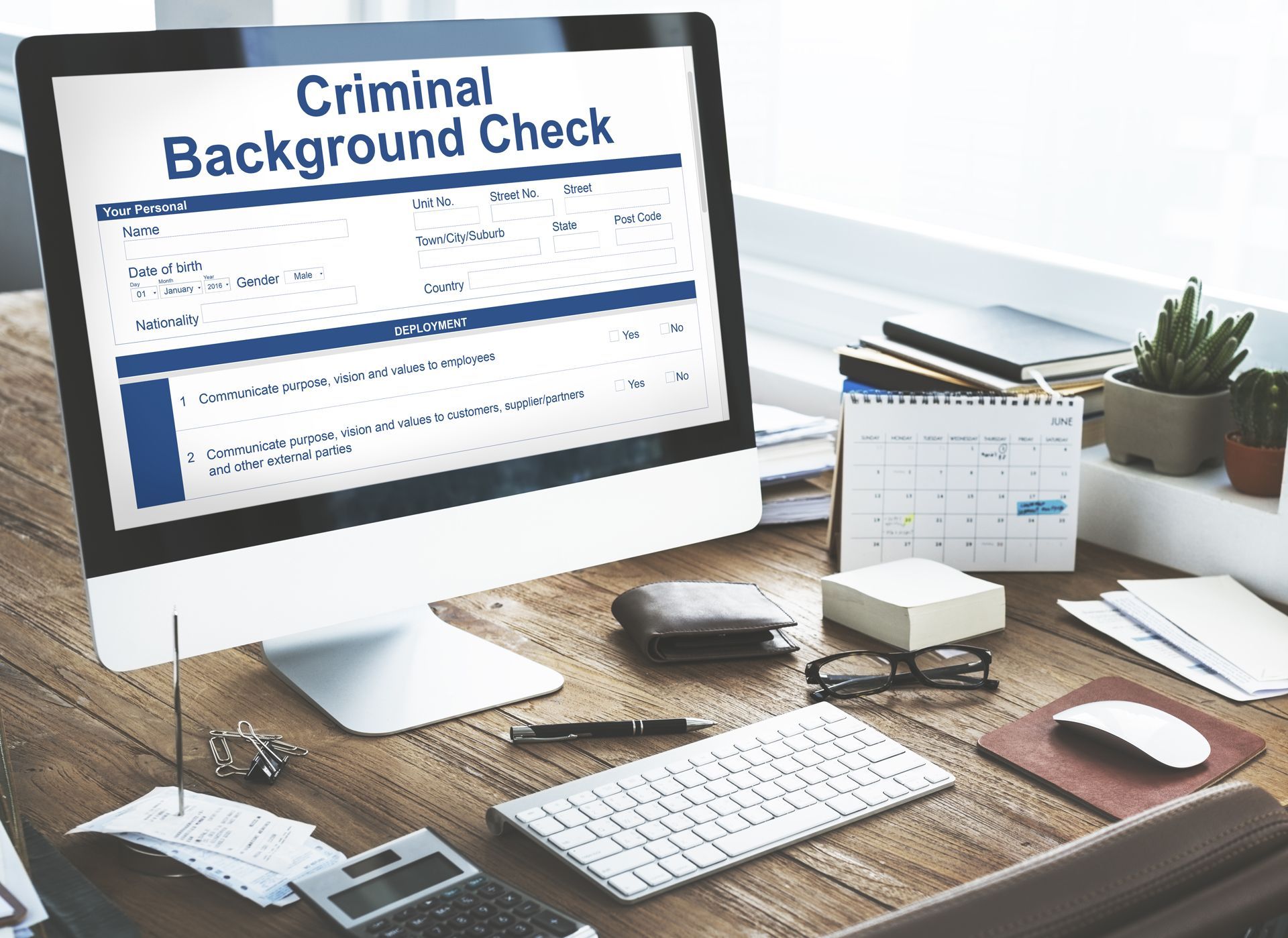 A Computer Monitor Displaying a Criminal Background Check on a Wooden Desk