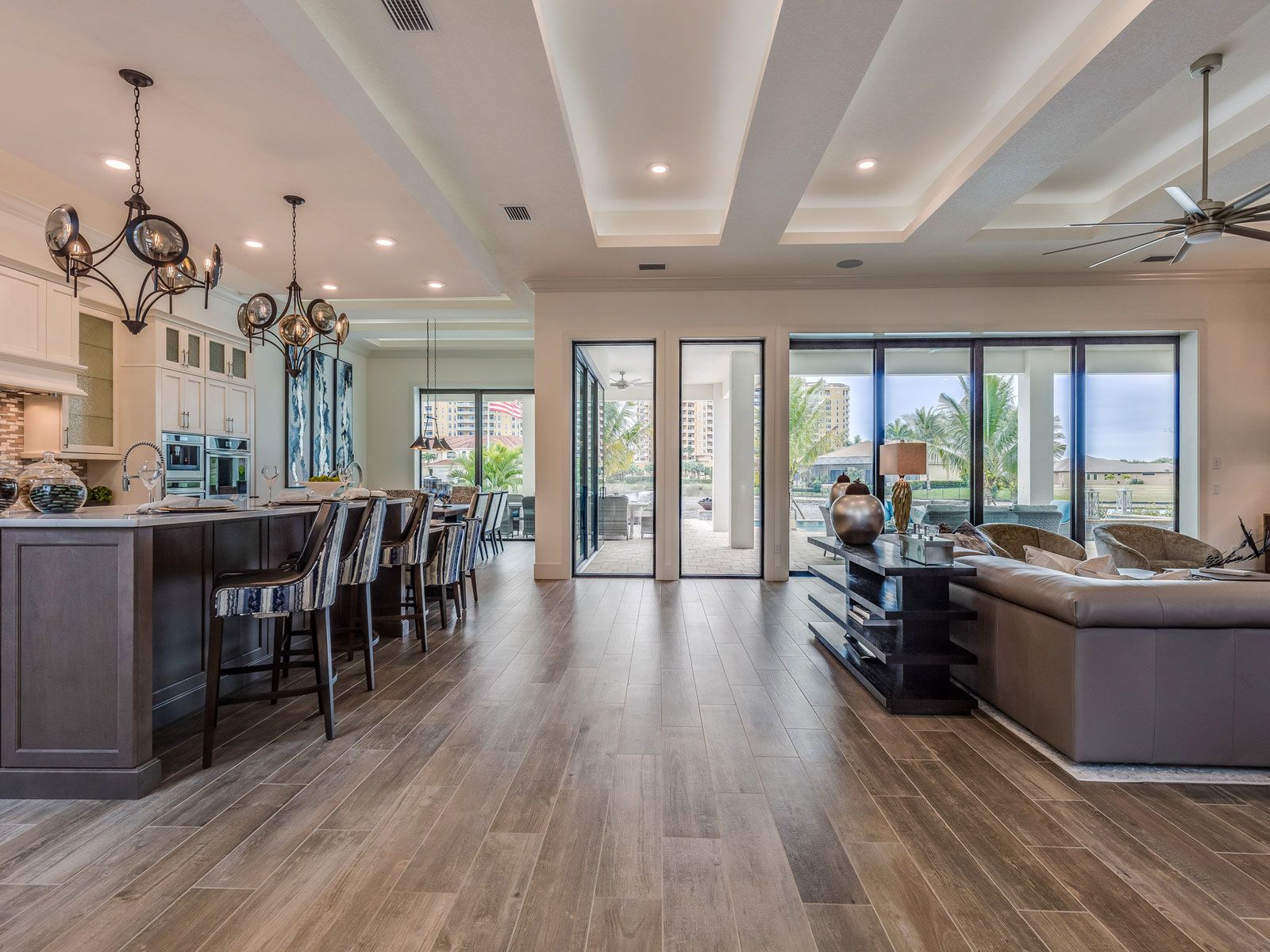 A large living room with hardwood floors and a kitchen.