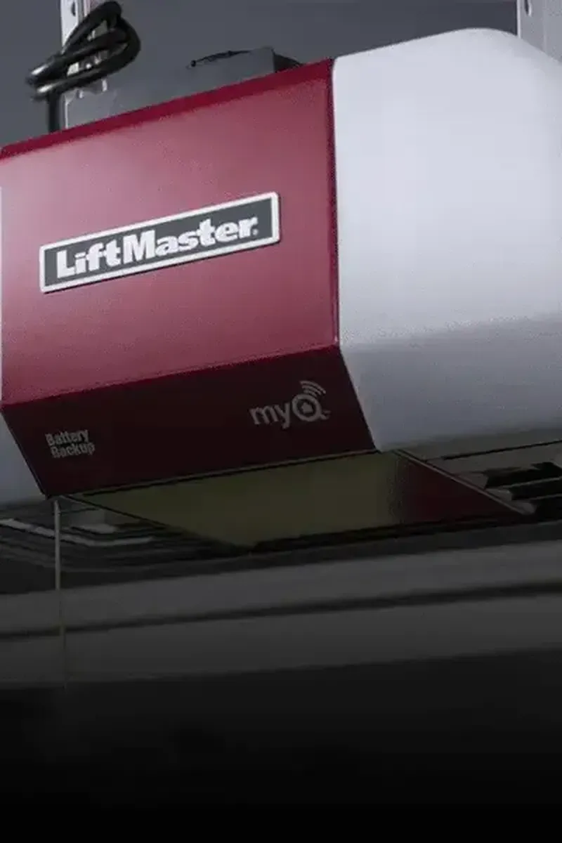 A red and white LiftMaster garage door opener mounted to a ceiling with a myQ logo visible on the side.