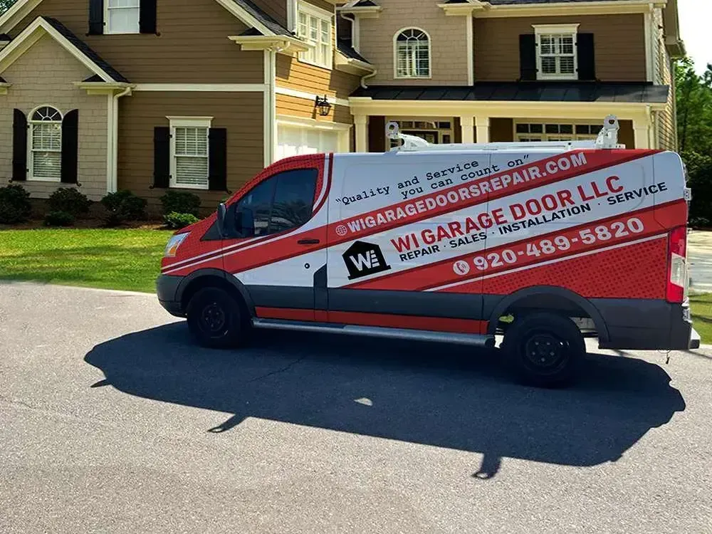 A white and red Wi Garage Door LLC work van parked in front of a residential home.