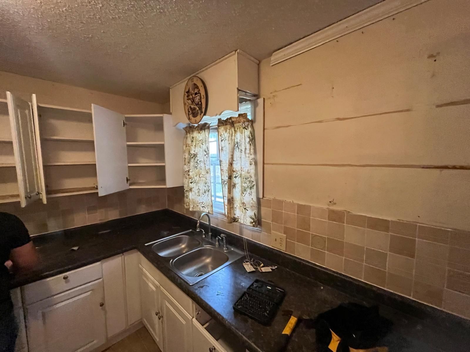 Kitchen with white cabinets, black countertops.