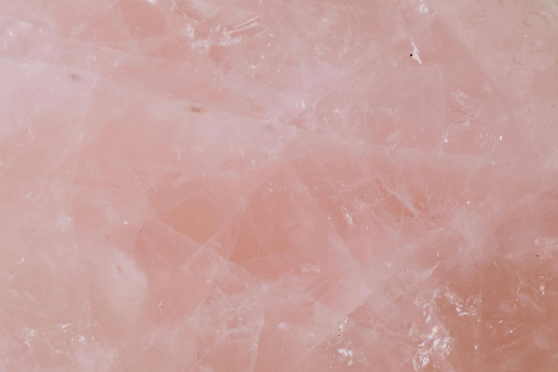 Close-up of a translucent, pale pink rose quartz gemstone, showing crystalline structure.
