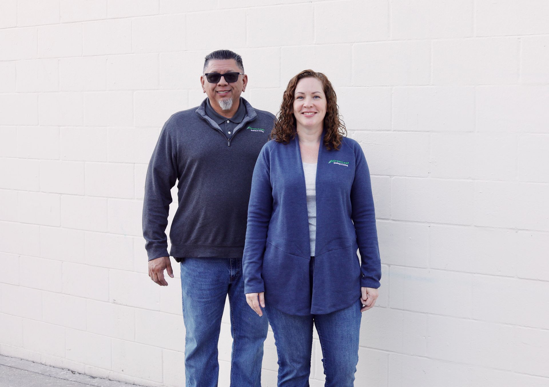 A man with a beard is smiling in front of a truck that says green