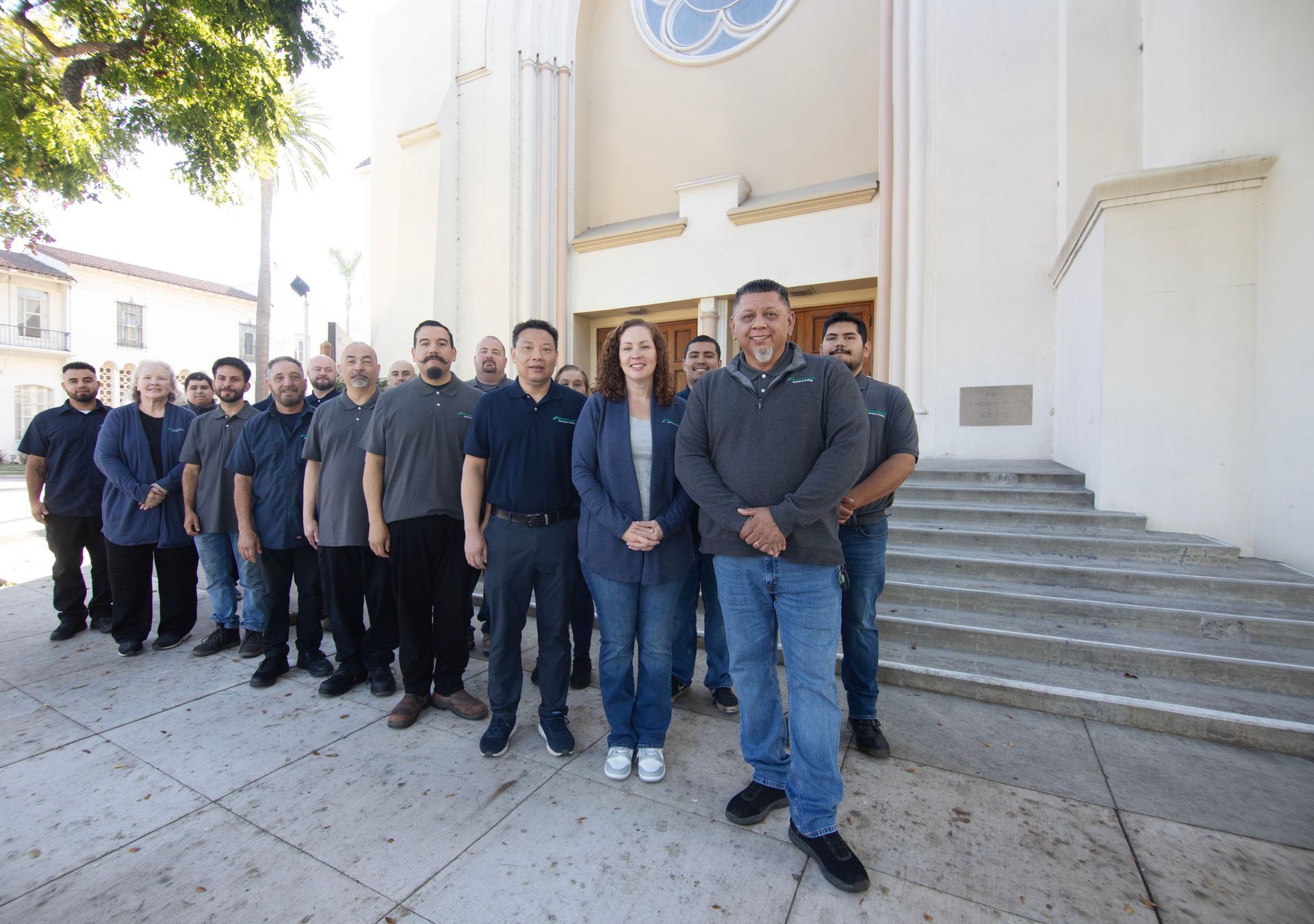 A group of people are posing for a picture on a sidewalk.