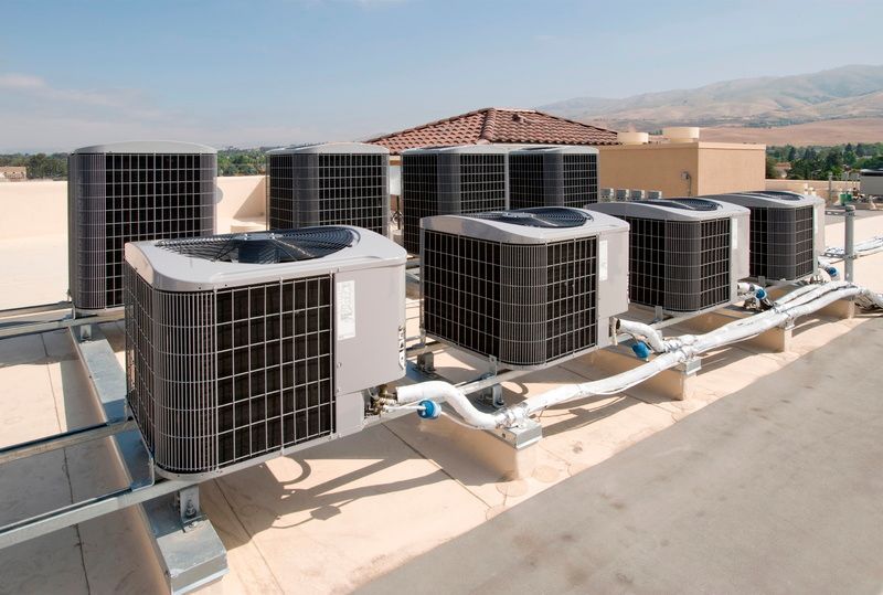 A row of air conditioners on the roof of a building.