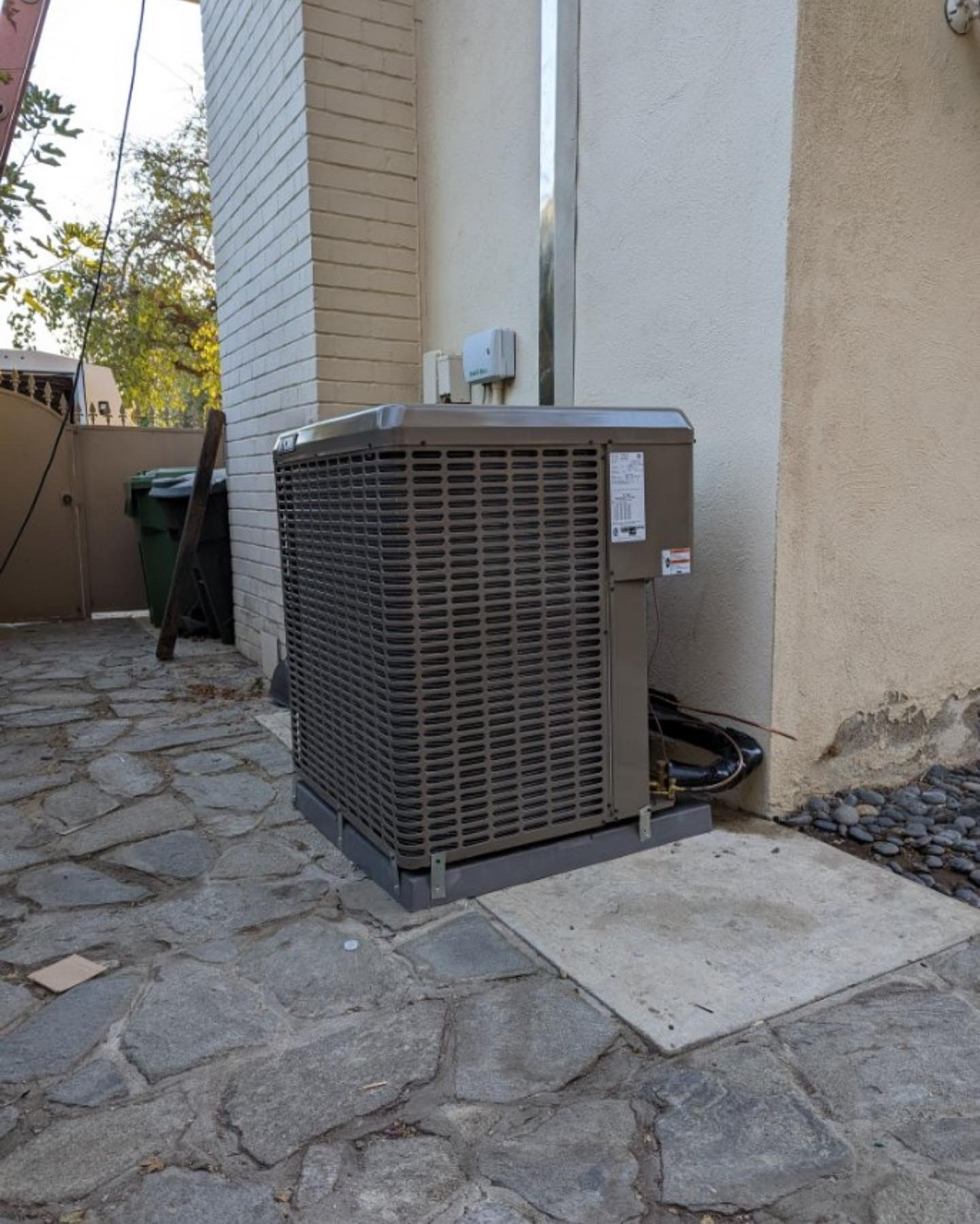 An air conditioner is sitting on the side of a building.