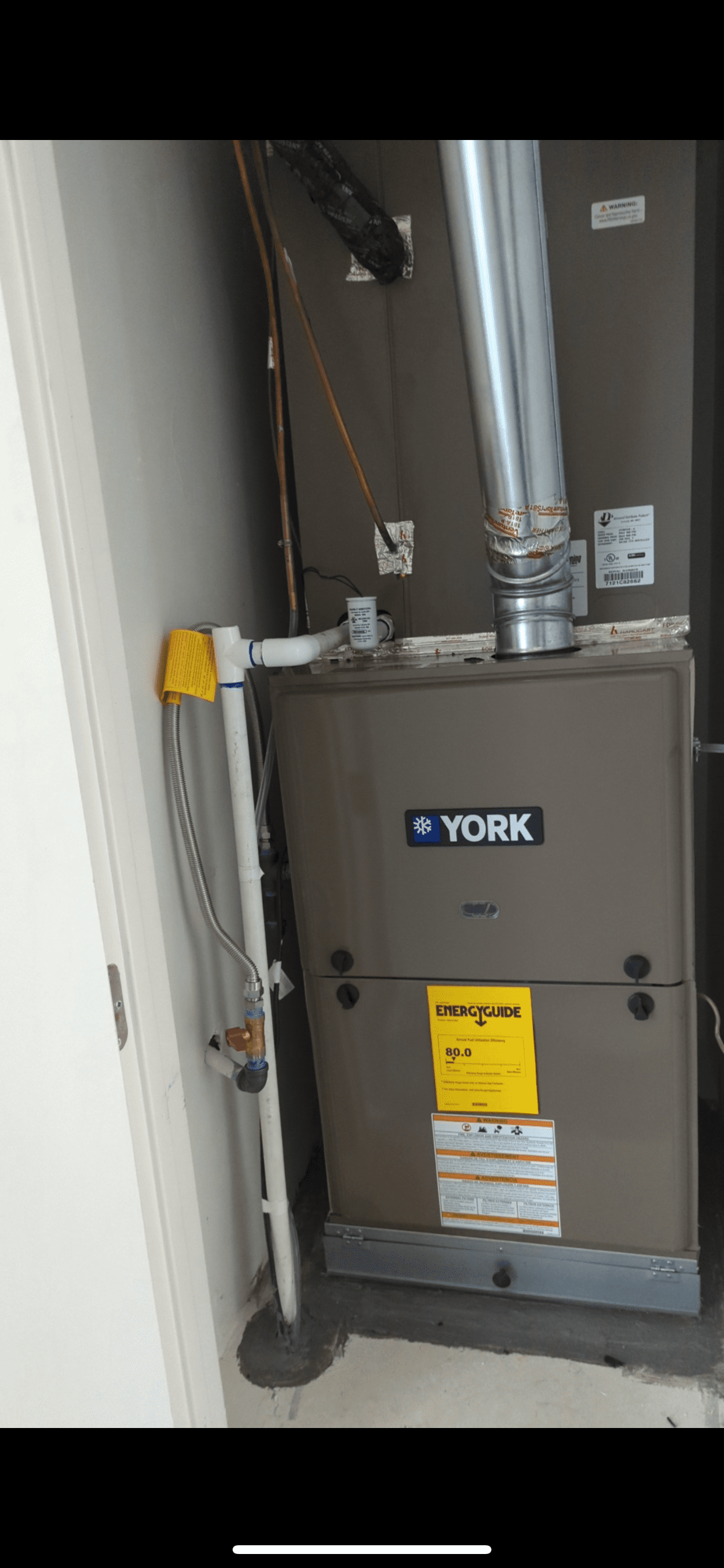 A york air conditioner is sitting in a room next to a door.