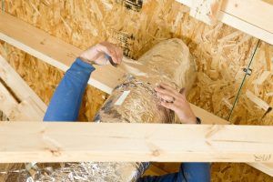 A person is working on a wooden structure in a house.