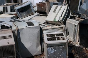 A pile of old air conditioners sitting on top of each other.