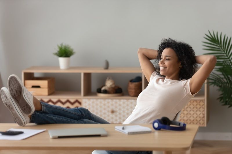 A woman is sitting at a desk with her feet up.