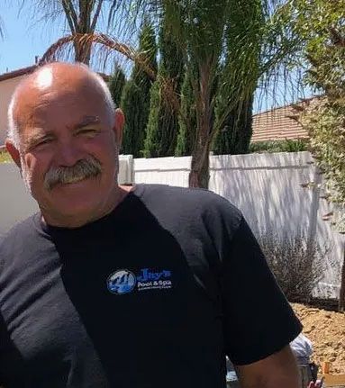 Man with mustache smiling, wearing black shirt with 
