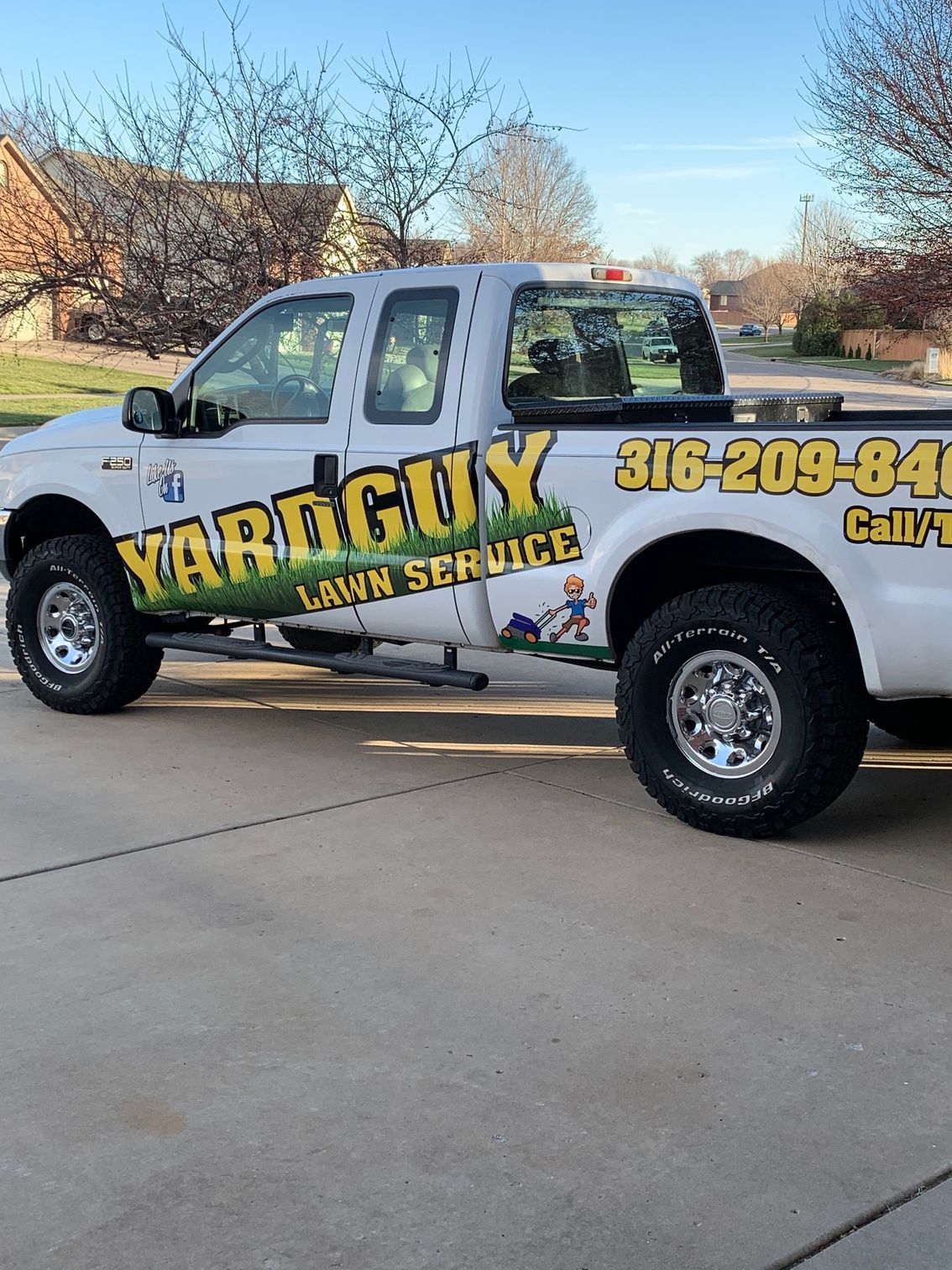 White Yard Guy lawn service truck parked in a driveway.