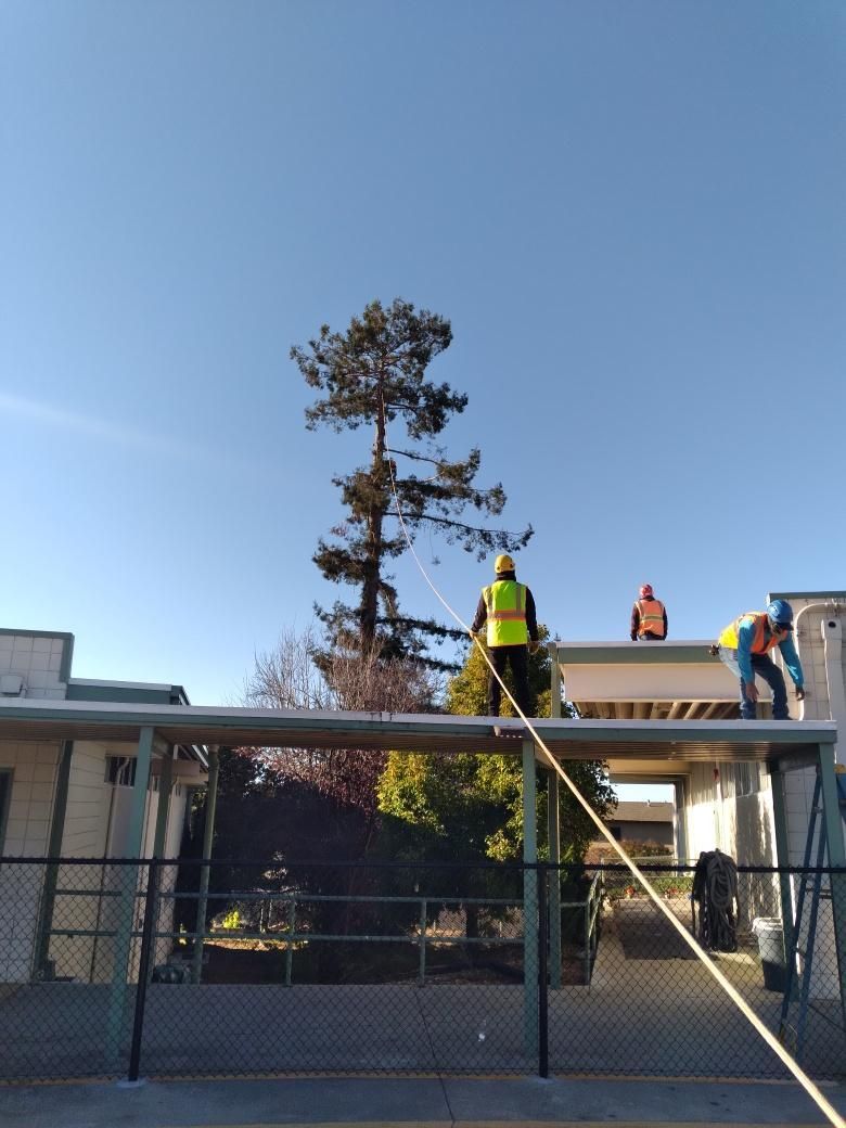 Two construction workers are working on the roof of a building
