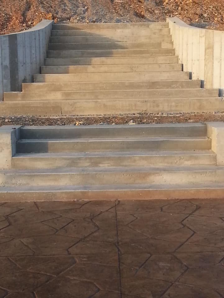 Concrete staircase leading upward. The steps are grey and flanked by concrete walls.